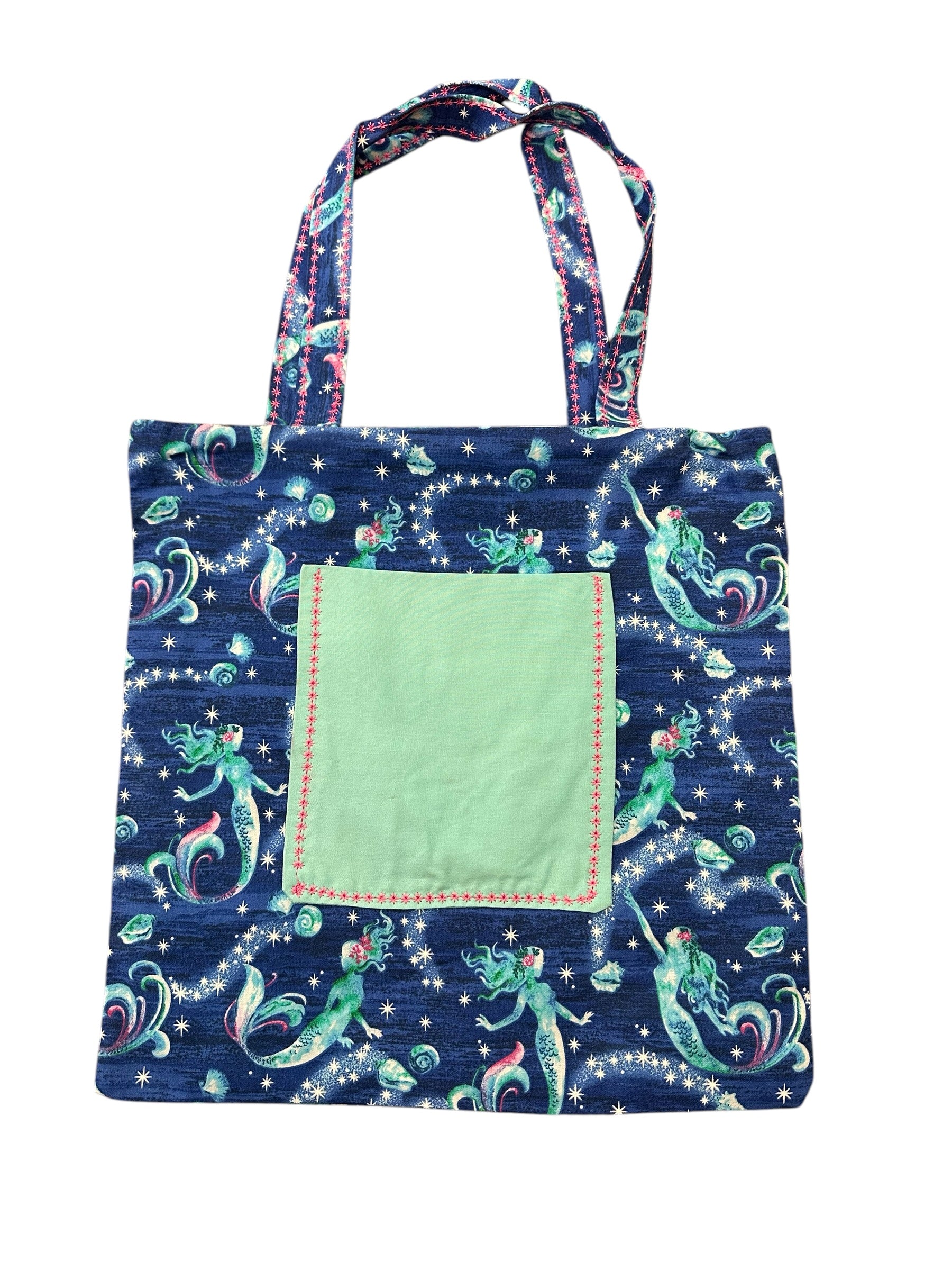 Tote bag with mermaid design and green pocket on a white background