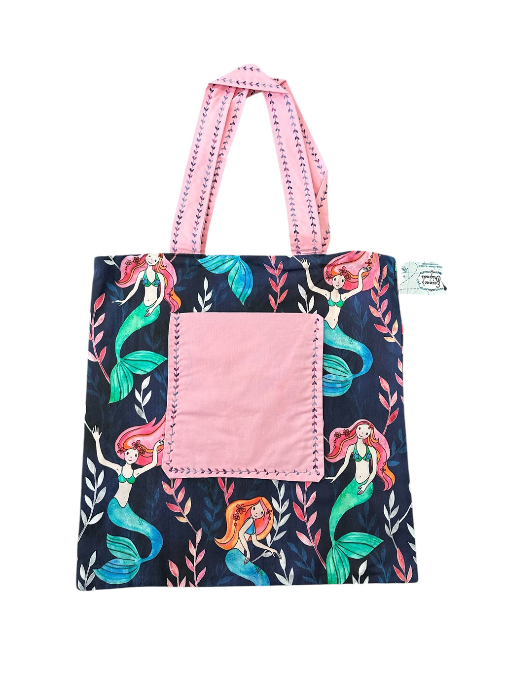 Tote bag with mermaid design and pink accents on a white background