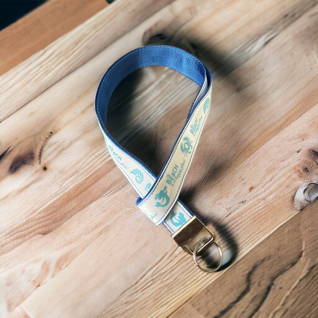 Blue lanyard with a metal clip on a wooden surface