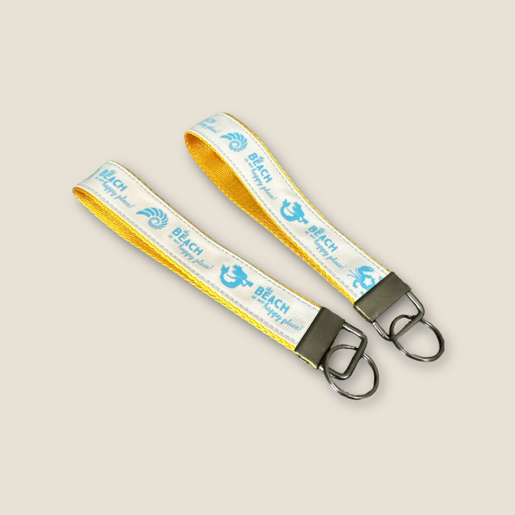 Keychain with yellow and blue strap on a beige background
