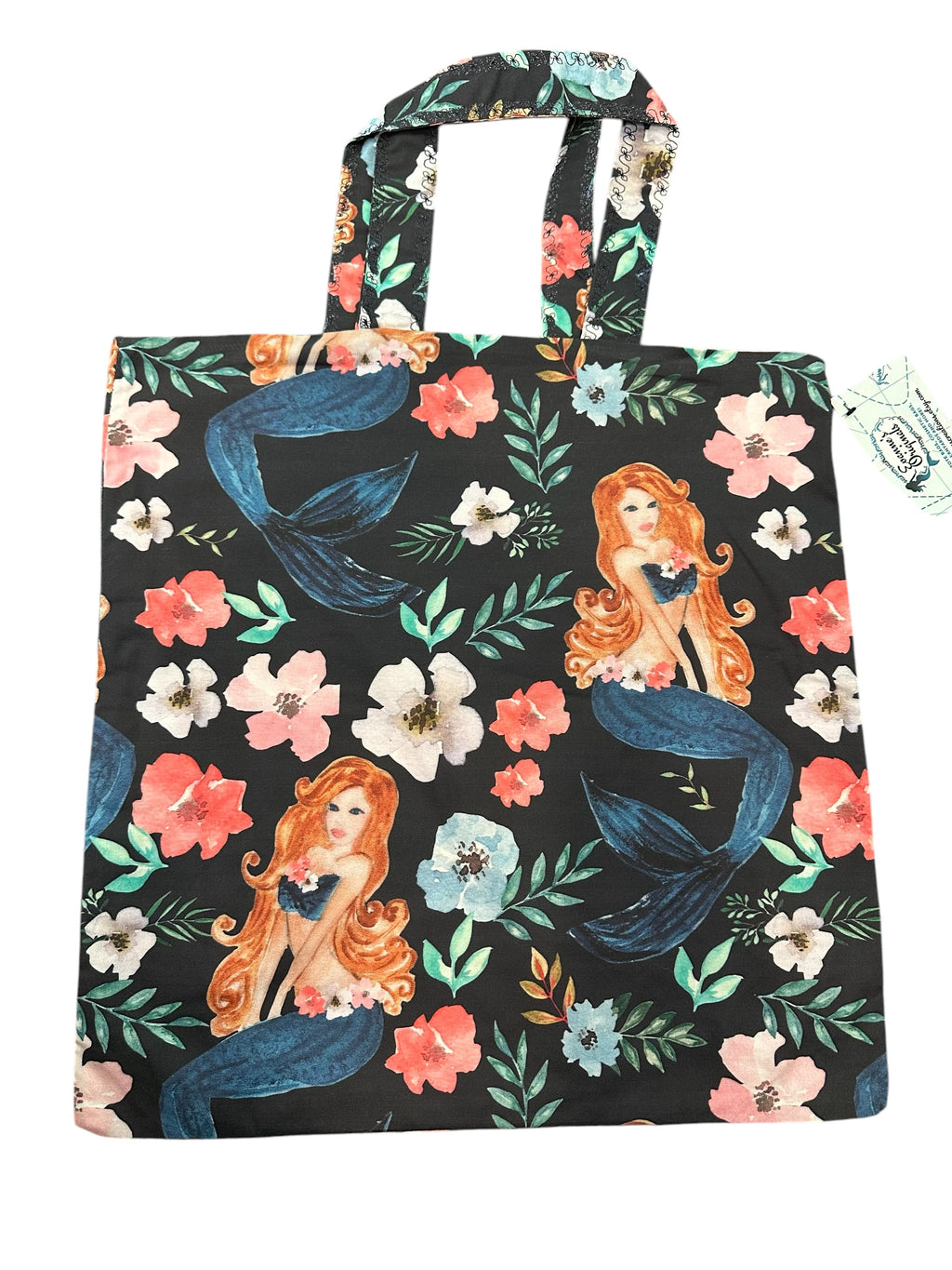 Tote bag with mermaid and floral design on a black background