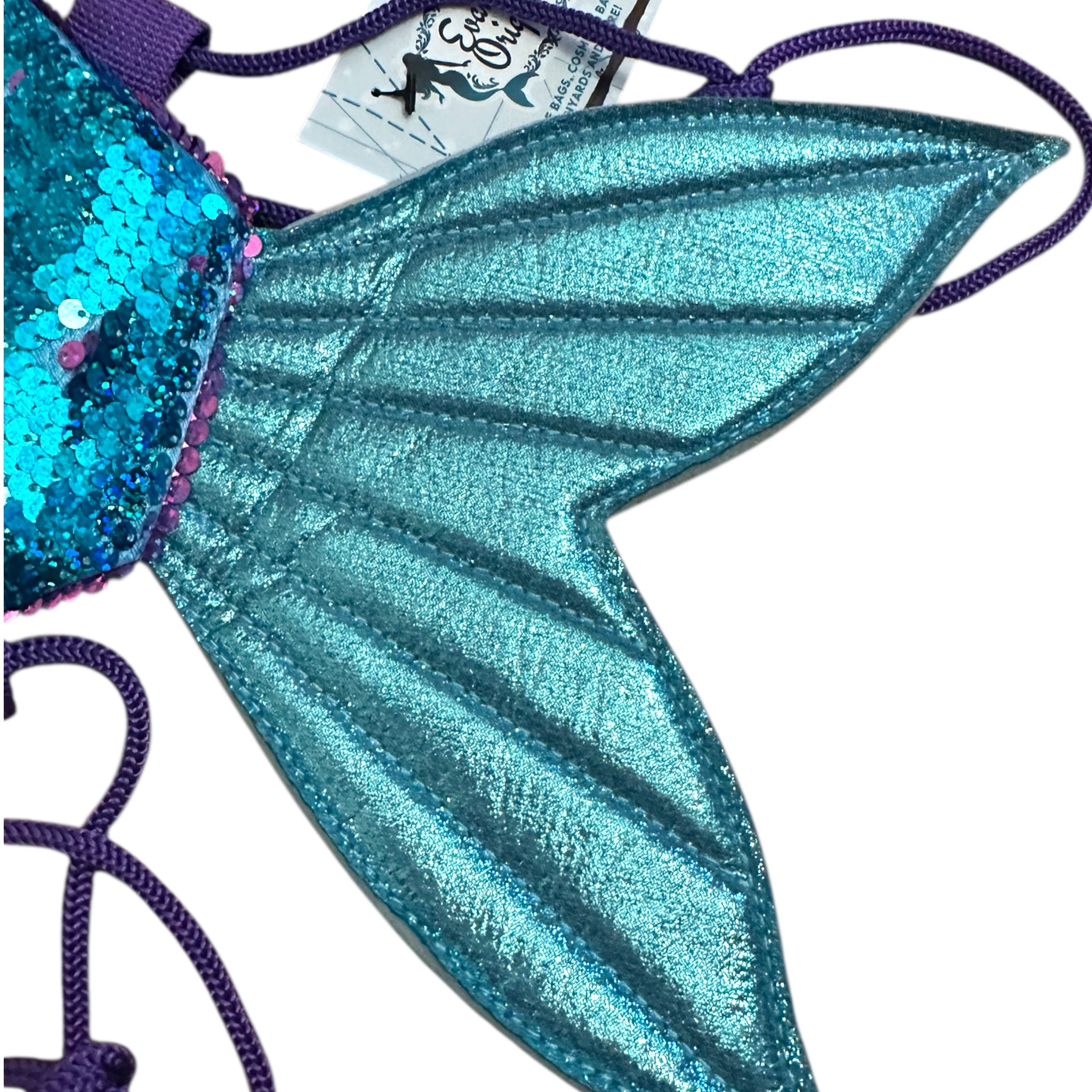 Turquoise glittery mermaid tail with purple accents on a white background