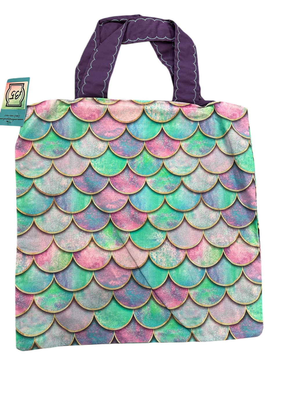 Tote bag with mermaid scale pattern and purple handle on a white background