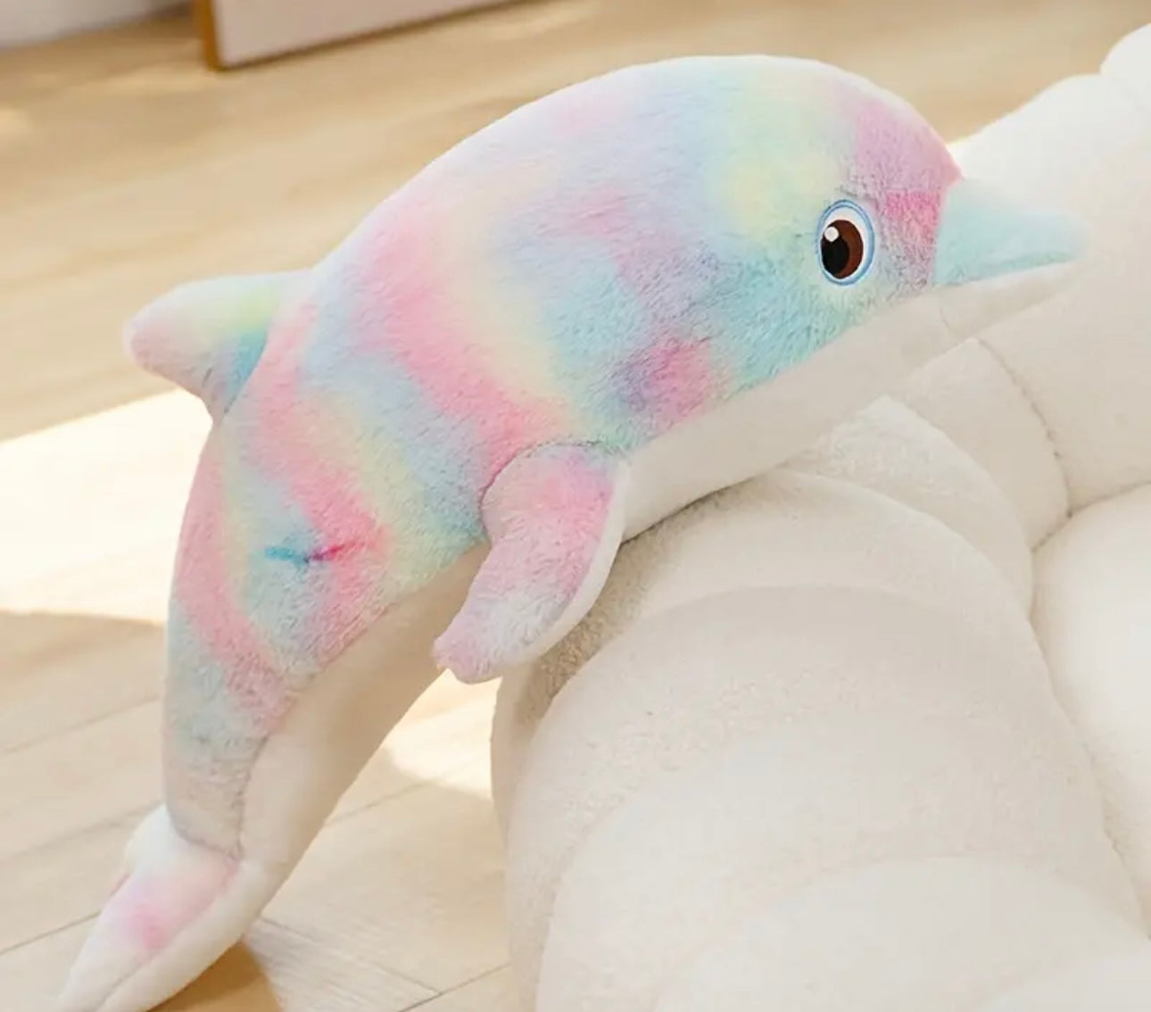 Colorful dolphin plush toy on a light-colored surface