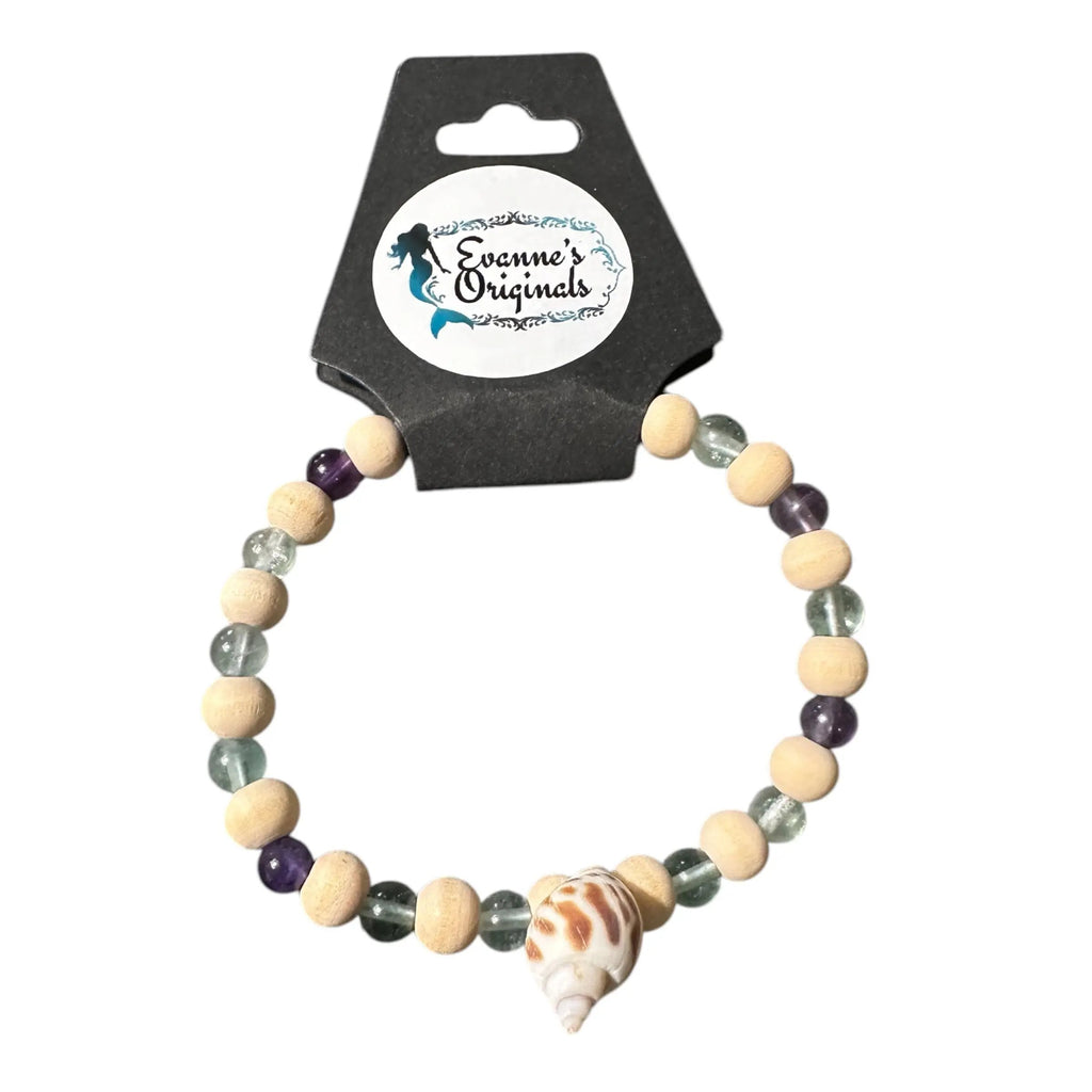 Beaded bracelet with a shell on a branded card against a white background