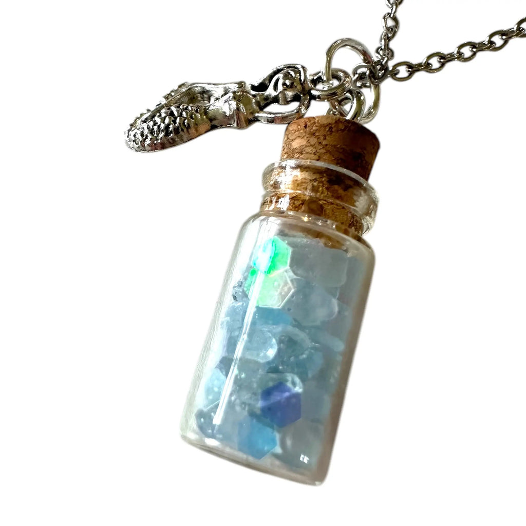 Necklace with a small glass bottle pendant containing colorful stones on a white background